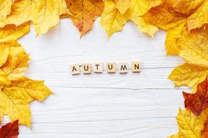 feuilles d'automne sur fond en bois. cadre de feuilles d'automne photo