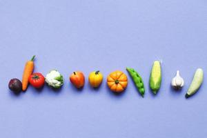 de nombreux légumes et fruits sur fond violet. concept d'aliments sains photo