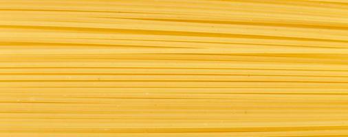 fond jaune spaghetti à proximité. macro de pâtes crues photo