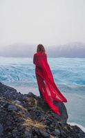 touriste avec cape rouge ondulant sur la photographie panoramique de roche photo