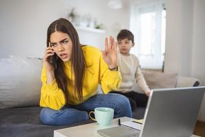 bureau à domicile. travailler à domicile ou maman avec un enfant travaille sur Internet sur un ordinateur portable à la maison. quarantaine. corona virus. mère fatiguée essayant de travailler sur un ordinateur portable à la maison pendant que son enfant pleure. photo