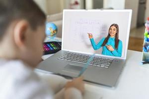 formation en ligne à distance. un écolier étudie à la maison et fait ses devoirs scolaires. un enseignement à distance à domicile. photo