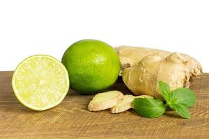 détail de gingembre frais entier et coupé au citron vert photo