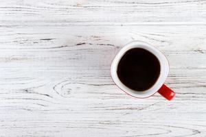 tasse à café rouge sur la vue de dessus de table en bois photo