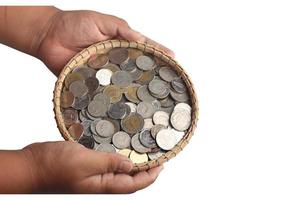 pièces de monnaie dans un panier en bambou sur fond blanc. concept d'économie d'argent photo