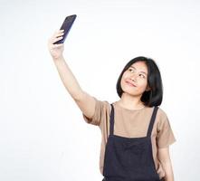 prendre un selfie à l'aide d'un smartphone d'une belle femme asiatique isolée sur fond blanc photo