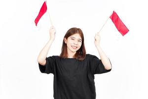 souriant et tenant le drapeau indonésien de la belle femme asiatique isolée sur fond blanc photo