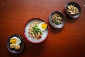 bouillie de congee avec tranche de poulet, tofu, oeuf. bouillie de congee de hong kong. nourriture chinoise photo