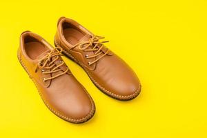 nouvelles chaussures en cuir marron pour hommes. tourné en studio isolé sur jaune