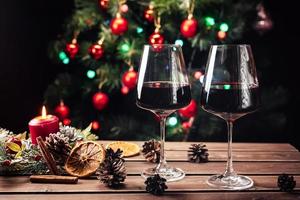 verres de vin sur le fond d'un sapin de noël décoré. humeur du nouvel an photo