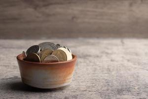 pièces de monnaie dans une tasse en bois. futur concept d'économie d'argent. espace de copie. photo