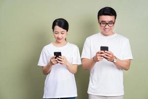 image d'un jeune couple asiatique utilisant un smartphone photo