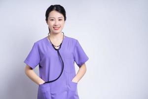 portrait de jeune infirmière asiatique sur fond blanc photo