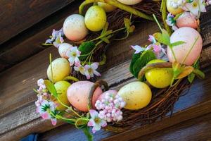 couronne d'oeufs de pâques avec des fleurs sur la porte d'entrée. décoration traditionnelle pour pâques. photo