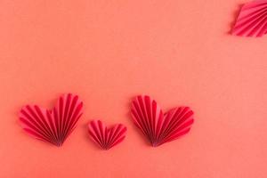 fond rouge monochrome avec des coeurs d'origami. notion de famille. St. La Saint-Valentin. photo