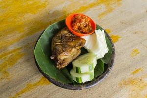 poulet grillé aux épices épicées cuit de manière traditionnelle avec du bois de chauffage. photo