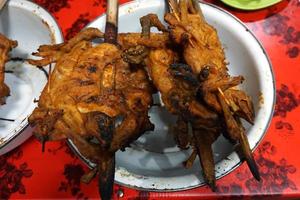 poulet grillé aux épices épicées cuit de manière traditionnelle avec du bois de chauffage photo