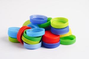 bouchons de bouteilles en plastique colorés pour recyclage sur fond blanc. photo