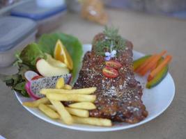 côtes de porc grillées avec frites sur plat photo