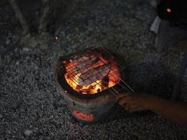 calmars grillés dans une grille en acier avec un gril à charbon de bois. photo