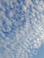 beaux nuages blancs sur fond de ciel bleu profond. image élégante de ciel bleu à la lumière du jour. de grands nuages doux et moelleux couvrent tout le ciel bleu. photo