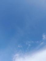 nuages blancs dans le ciel bleu. beau fond bleu clair. peu nuageux, beau temps. nuages bouclés par une journée ensoleillée. photo