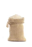 Riz au jasmin brut biologique blanc dans un sac de sac de jute isolé sur fond blanc photo