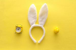 oeufs de pâques décorés et oreilles de lapin sur fond jaune de couleur, vue de dessus photo