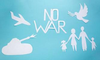 il n'y a pas de guerre. une famille, une colombe de la paix découpée dans du papier sur fond bleu.le concept de la journée mondiale de la paix photo