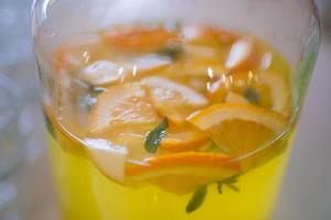 un grand pot avec de la limonade maison fraîche et des tranches d'orange. photo