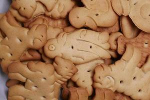 Biscuits sucrés en forme d'animal dans un bol blanc sur fond jaune photo