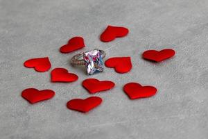 veux-tu m'épouser. bague de mariage de nombreux coeurs rouges sur fond gris pierre béton. concept de mariage de proposition de mariage de fiançailles. St. carte postale de la saint valentin. bannière le jour de la saint valentin. photo