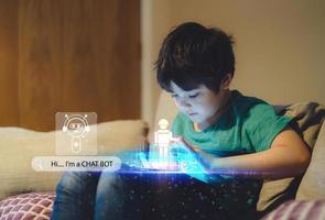 concept d'apprentissage de la technologie de l'éducation, enfant utilisant un chat bot construisant un jeu de robot sur tablette avec icône de visage de notification pop-up, garçon programmant un robot avec écran d'exposition surfant sur le web, interface de diagramme cyber photo