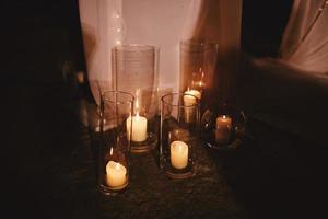 décoration de mariage avec bougies allumées et tissu blanc dans les lumières du soir sur fond sombre. mise au point sélective photo