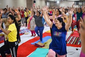 delhi, inde, 19 juin 2022 - séance d'aérobic de yoga en groupe pour les personnes de différents groupes d'âge dans le temple balaji, vivek vihar, journée internationale du yoga, grand groupe d'adultes assistant à un cours d'aérobic dans le temple photo