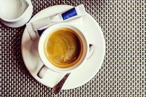 tasse de café avec de la mousse sur la vue de dessus de table en métal photo