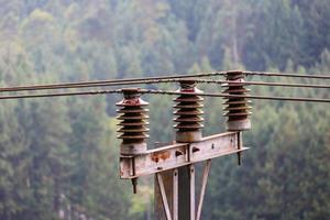 une vue de grands poteaux électriques sur fond de collines et d'arbres photo