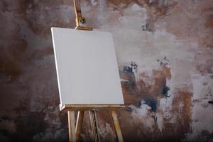 toile artistique vide blanche sur un chevalet pour dessiner des images par un artiste sur fond gris photo