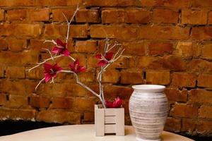 Orchidée rouge dans un pot en bois sur une table photo