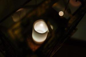 lanterne de noël avec des bougies de neige vue depuis la fenêtre sur le fond de la rue de nuit photo