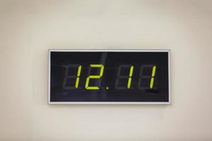 Horloge numérique noire sur fond blanc indiquant l'heure douze heures onze minutes photo