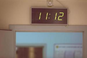 Horloge numérique noire sur fond blanc indiquant l'heure onze heures douze minutes photo