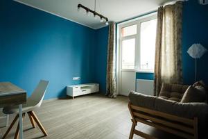 intérieur moderne de chambre avec fauteuil sur fond de mur bleu photo