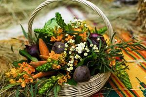 panier avec des légumes biologiques sur l'herbe verte et les fleurs. en plein air. légumes fraîchement récoltés. légumes crus dans un panier en osier.panier de légumes et de fleurs photo