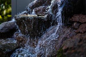 gros plan d'éclaboussures d'eau sur les rochers d'une chute d'eau photo