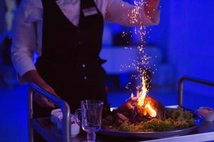 chef, verser de l'alcool dans une poêle à frire avec le feu photo