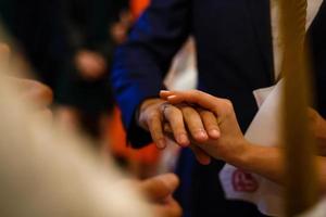 Le marié glisse l'anneau sur le doigt de la mariée au mariage photo