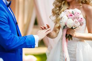 les mariés échangent des alliances lors d'une cérémonie de mariage, un mariage dans le jardin d'été photo