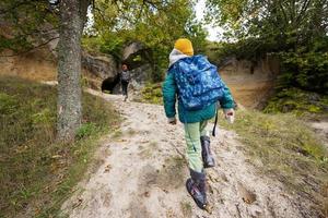 deux frères portent un sac à dos explorent des grottes de pierre calcaire à la montagne à pidkamin, en ukraine. photo