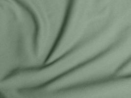 texture de tissu de velours de couleur verte utilisée comme arrière-plan. fond de tissu vert olive clair de matière textile douce et lisse. il y a de l'espace pour le texte.
